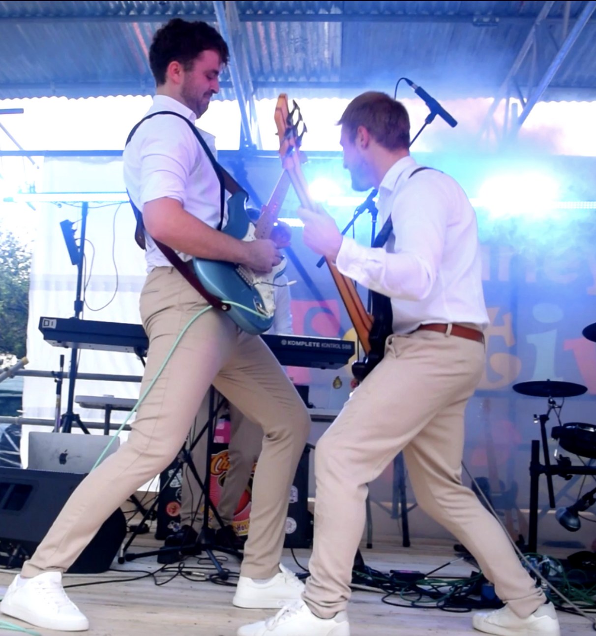 AMPLFY guitarists performing energetically on stage