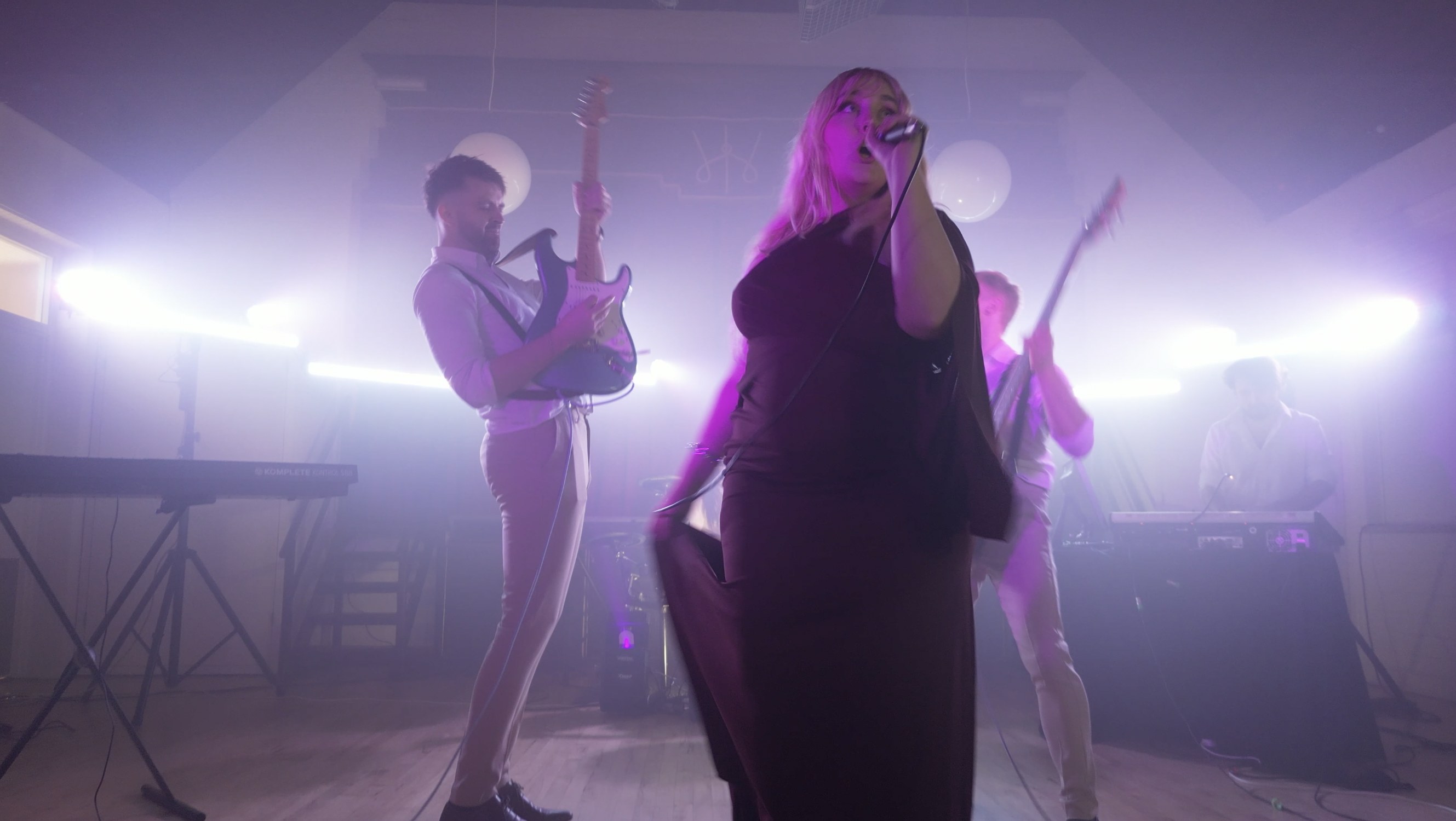 AMPLFY performing live on stage under purple stage lighting